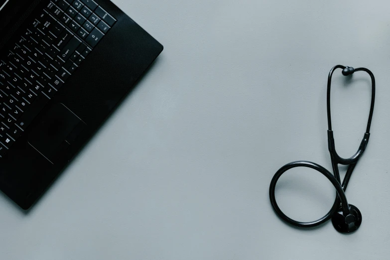 a black pair of scissors is next to a laptop