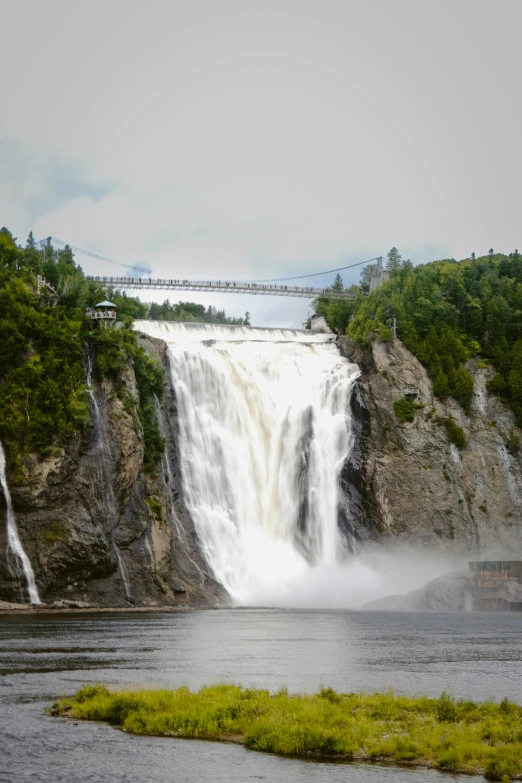 large waterfall with a bridge in the background