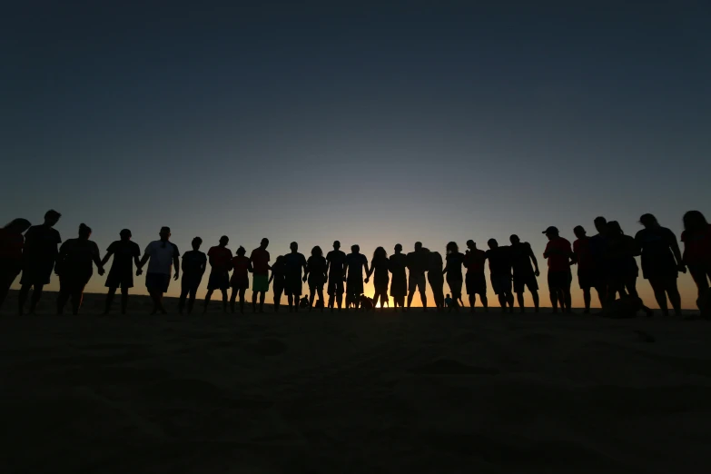 a group of people that are standing in the sand