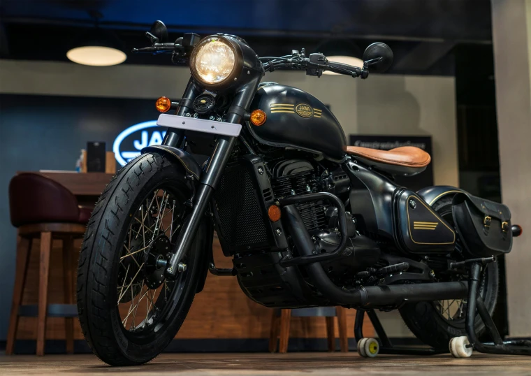 a black motorcycle parked in front of a wooden table