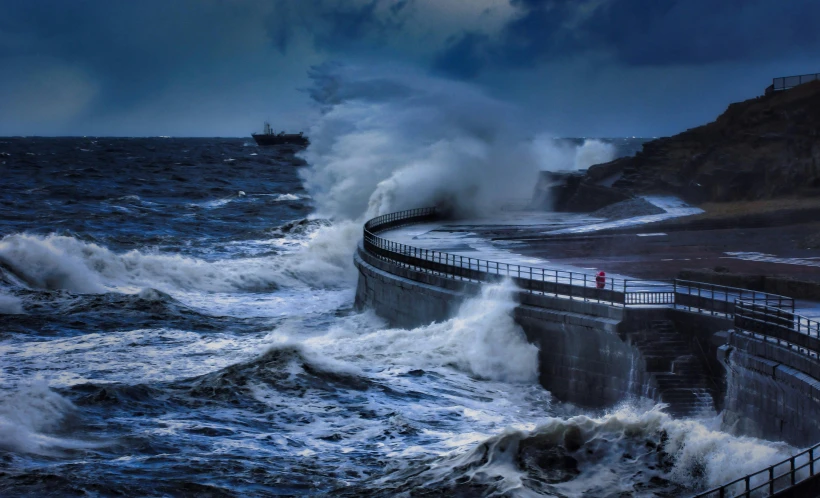 there is a wave coming into the shore near the pier