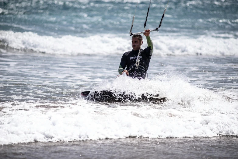 the person in black wetsuit is water skiing