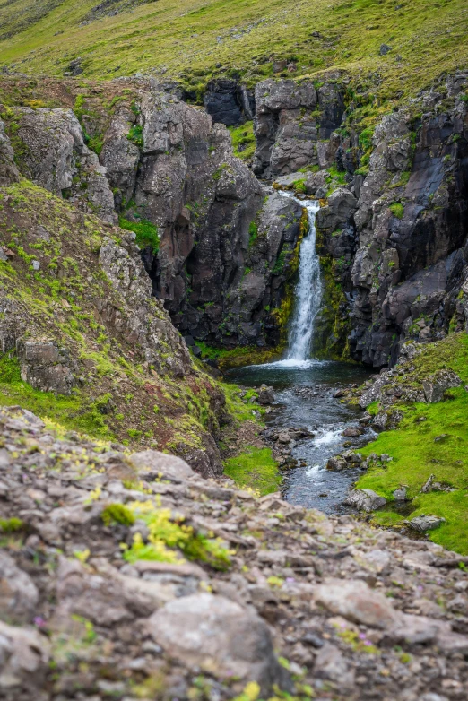 a small waterfall flows down into a valley of rocks