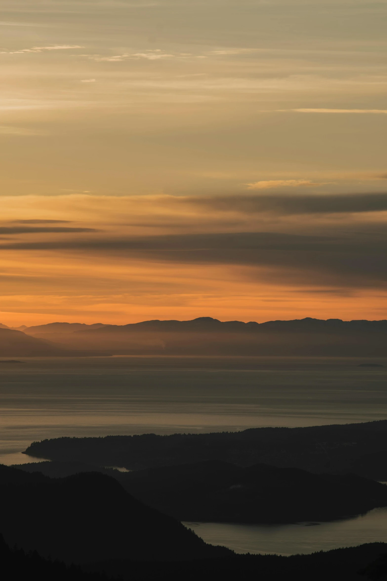 a plane is sitting in the sunset with a view over some mountains