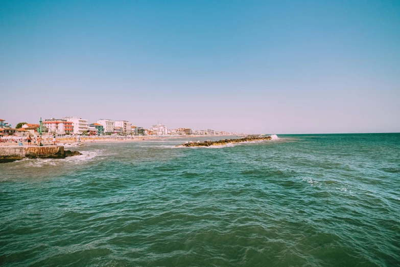 ocean view with houses in the background in bright blue sky