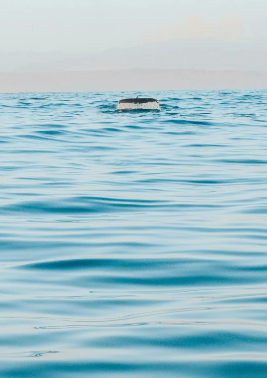 a boat is floating in the ocean with only a few people in it