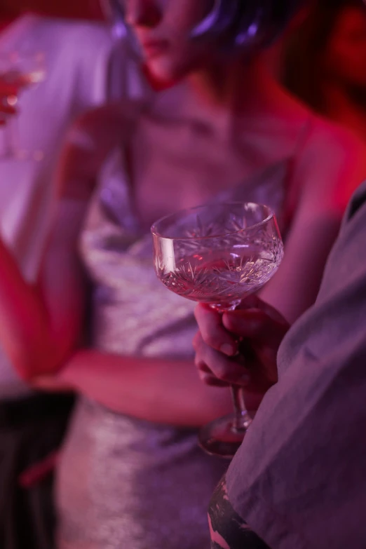 woman holding an alcoholic wine glass while looking at another