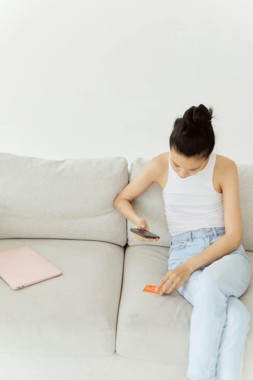 a girl is sitting on the sofa reading a book