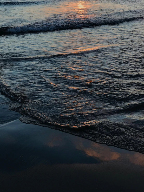 a beautiful sunset with the water rushing on the sand