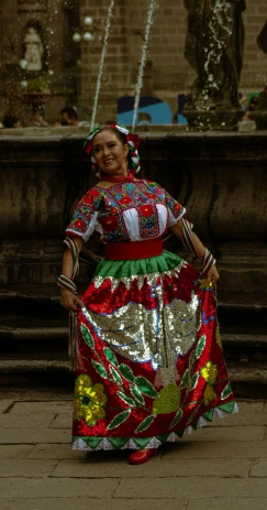 a woman standing on the sidewalk with a colorful dress