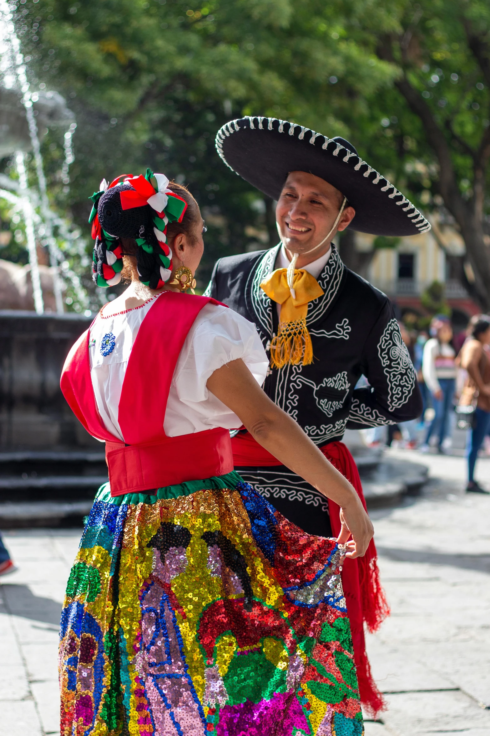 a man in a sombrero walks next to a woman with a large sombrero