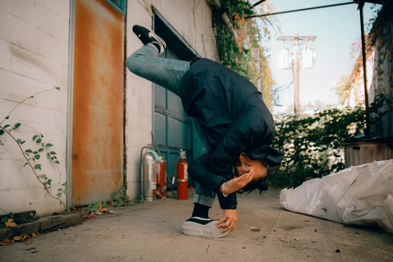 a young man doing a handstand on top of his skateboard
