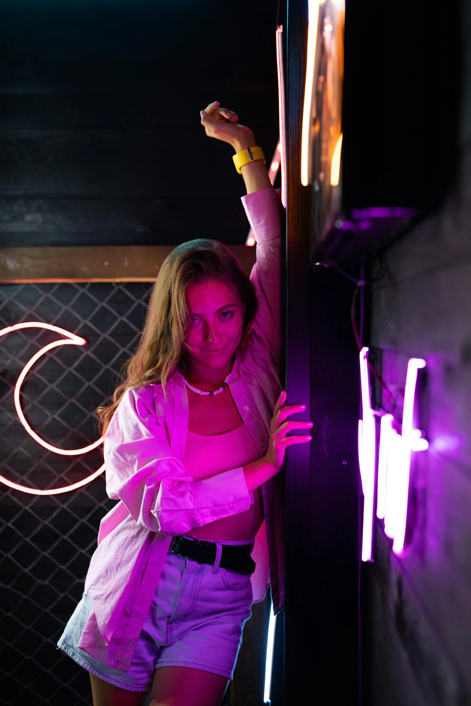 a woman is leaning against a wall holding onto soing purple