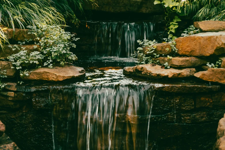 small waterfall surrounded by a rock wall and trees