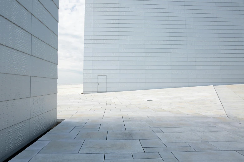 a cement wall is behind two white building