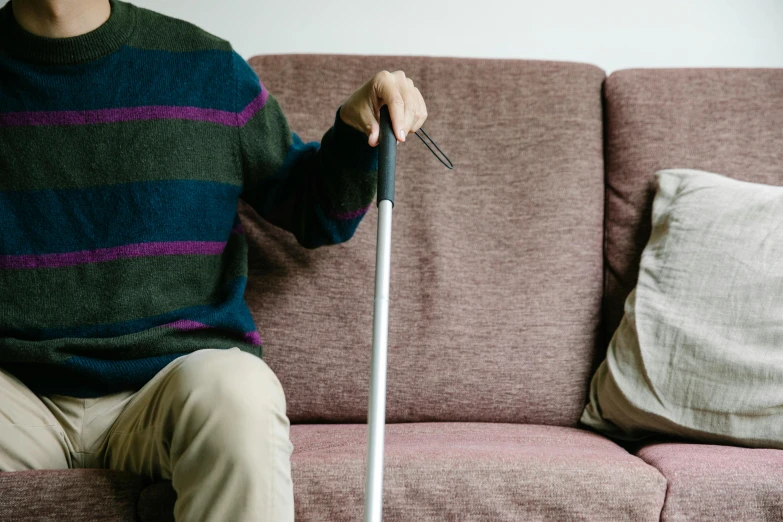 a person sitting on the couch while holding an object in his hand