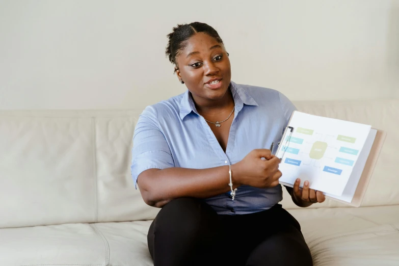 a woman holding a book on a couch