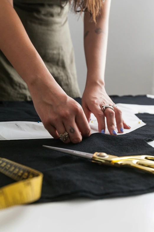 a woman holding scissors in one hand while  fabric