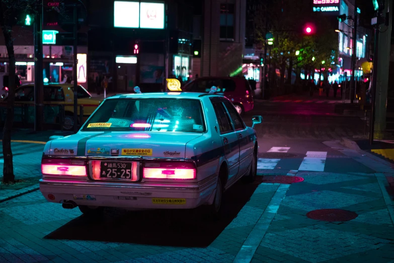a white car on a city street at night