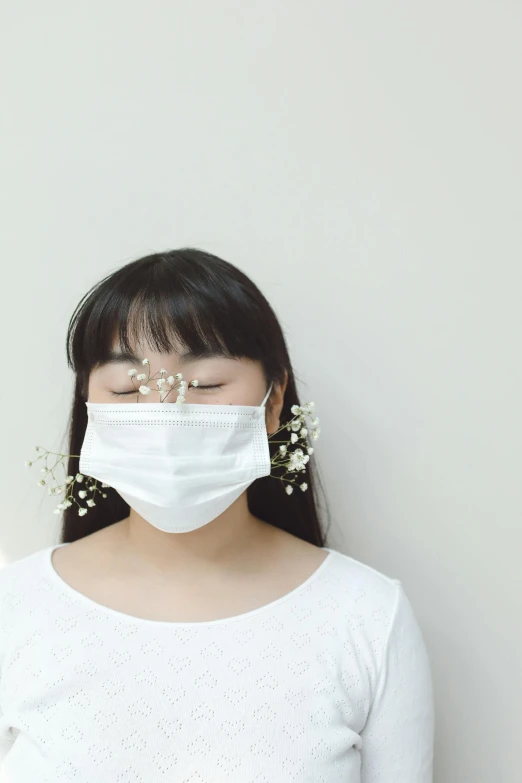 a woman is wearing a white face mask to protect her eyes