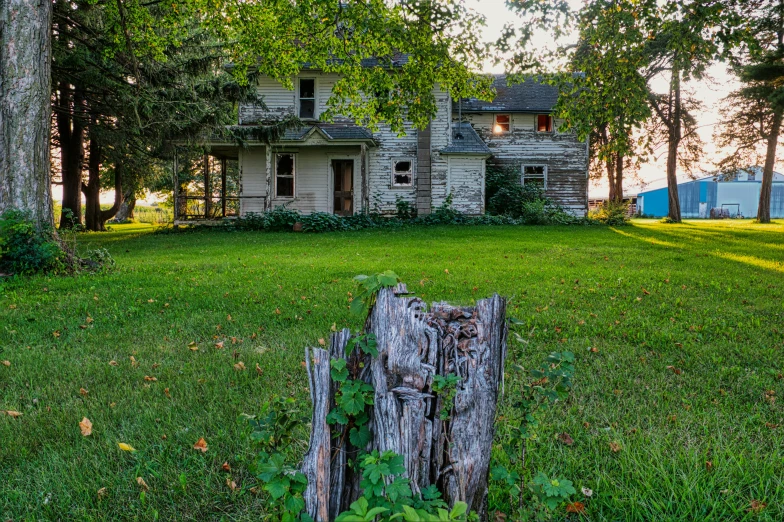 an old abandoned farm house on a green pasture