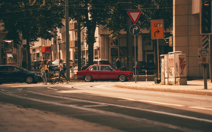 there is an old red car parked in front of the bus stop