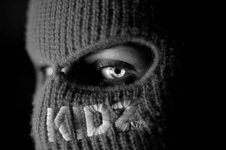 a black and white po shows a person's face, hiding a persons eye