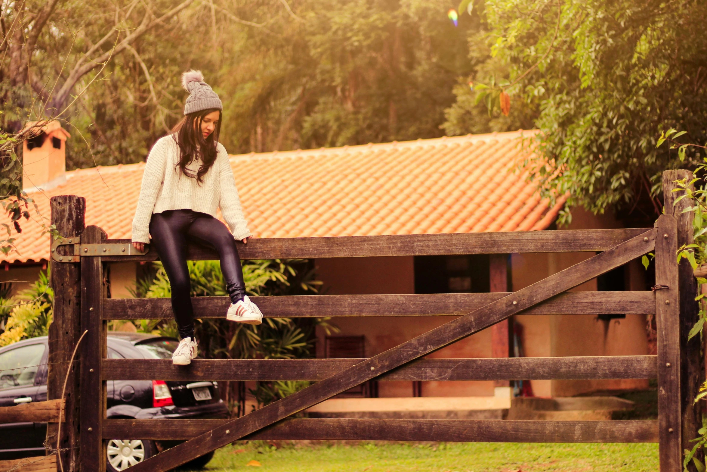 a woman that is sitting on top of a fence