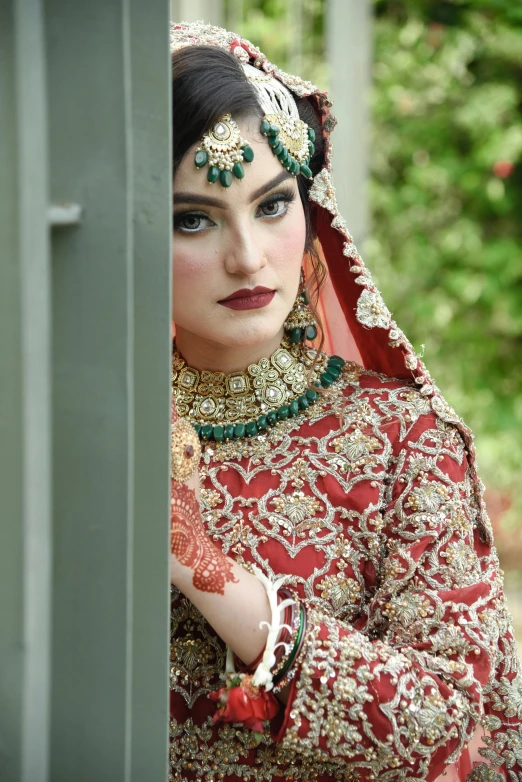 a beautiful woman dressed in a red bridal outfit