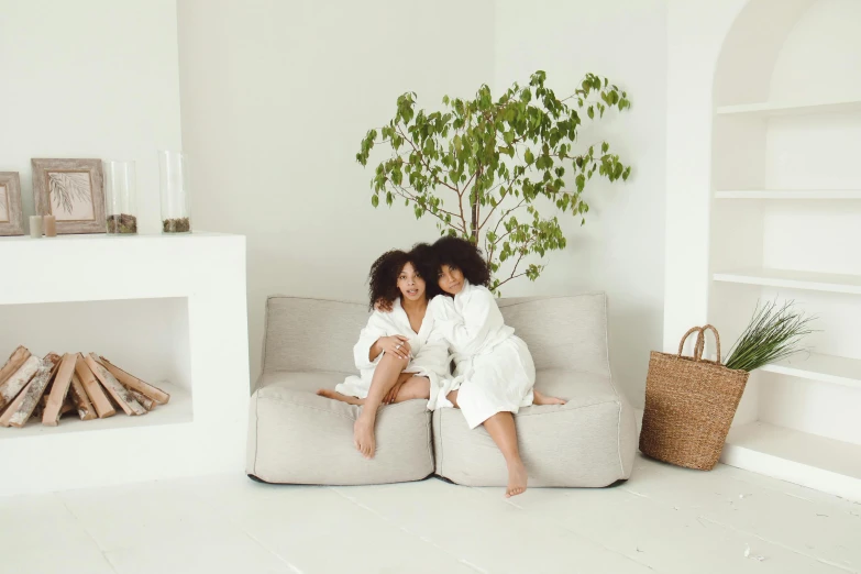 two women in robes sitting on a sofa