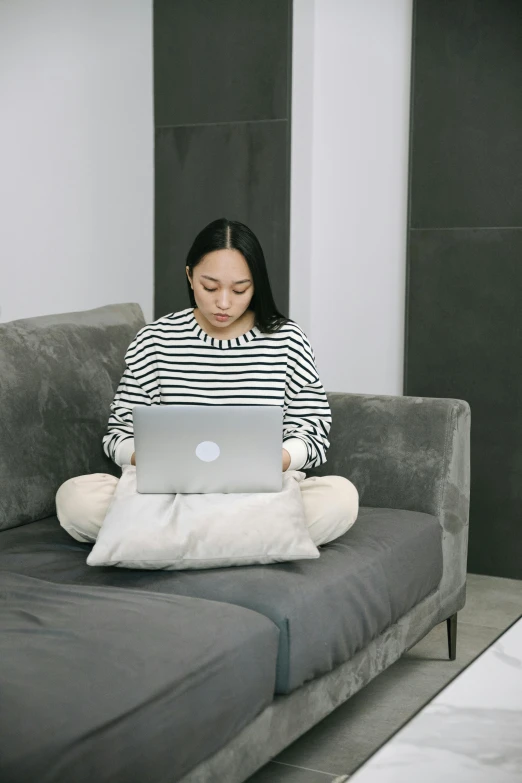 a woman on a couch using a laptop