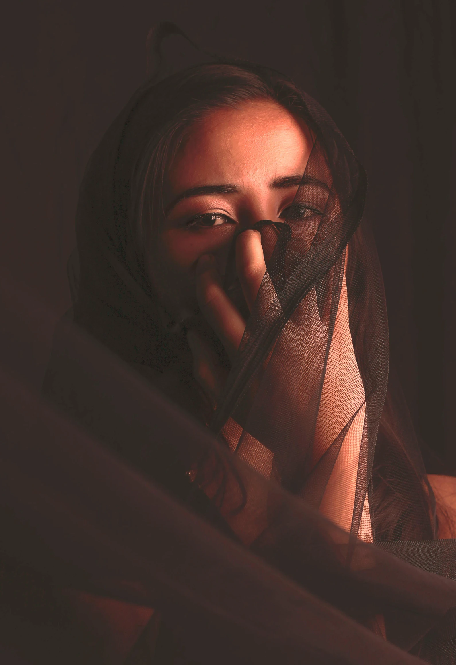 a woman has her nose covered by a curtain