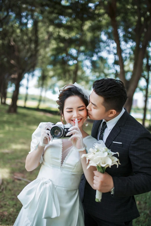 a bride and groom posing with a camera