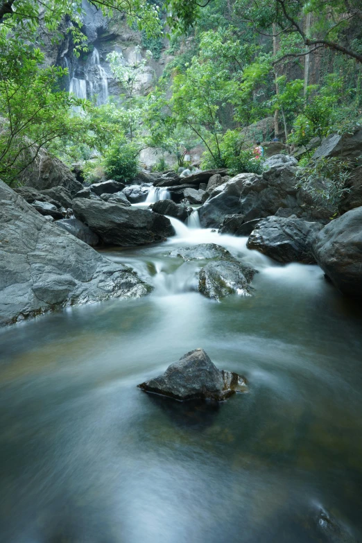 a small river with a waterfall coming down the side