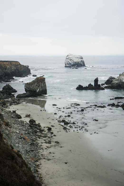 a rocky beach with the ocean in the background