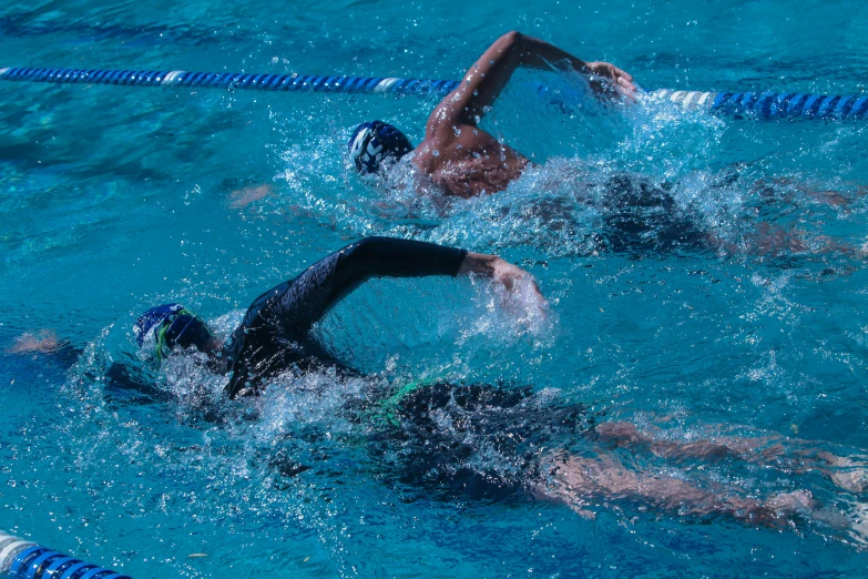 two swimmers in the pool competing to get up