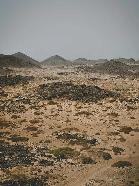 a barren area with dirt hills and scrub scrub