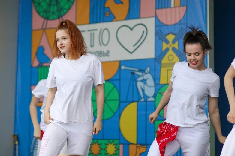 two female model performing in front of a colorful backdrop