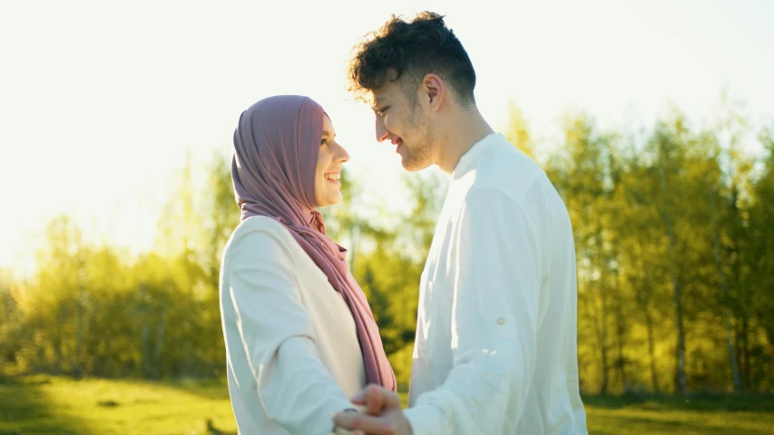 a young couple holding hands and looking into each others eyes