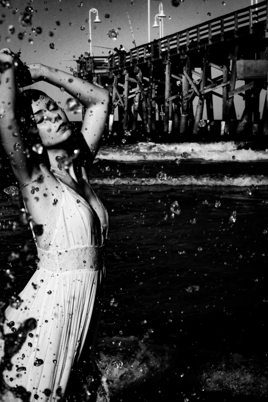 a girl in a bathing suit in water at a pier