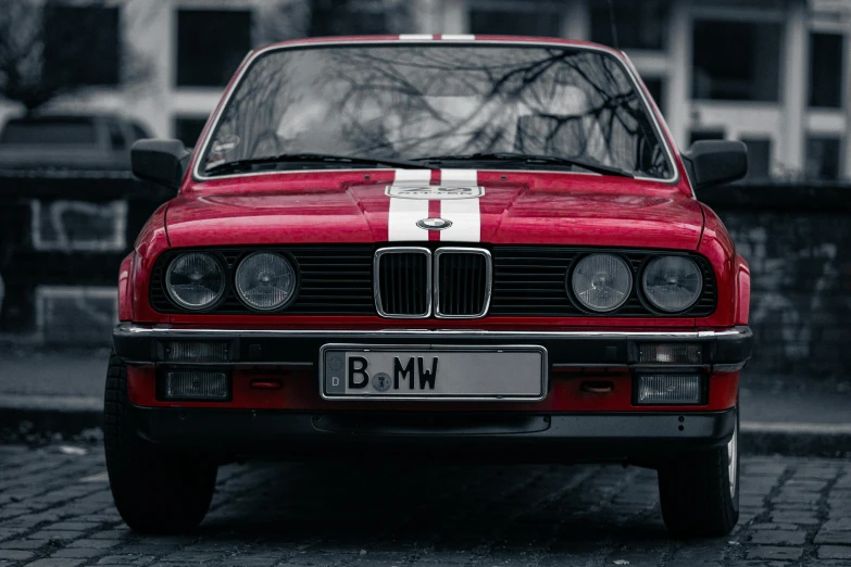 this red bmw is parked in a brick area