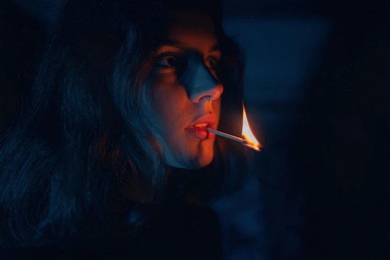 a woman with a cigarette in her mouth and an almost lighter