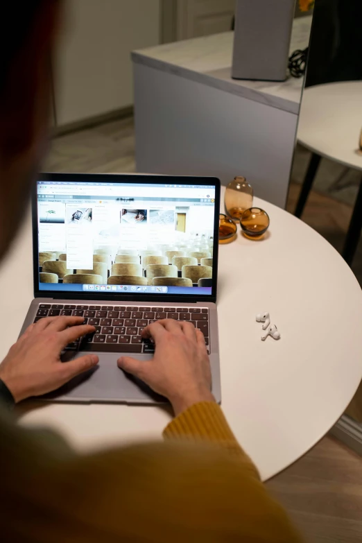 a person is typing on the keyboard of an open laptop