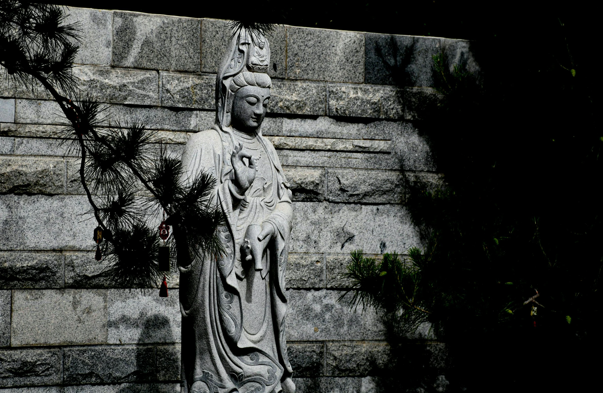 a statue of buddha is shown in front of a brick wall