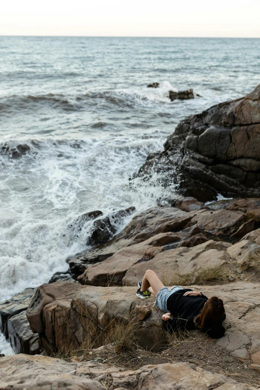 there is a person that is laying down on the rock