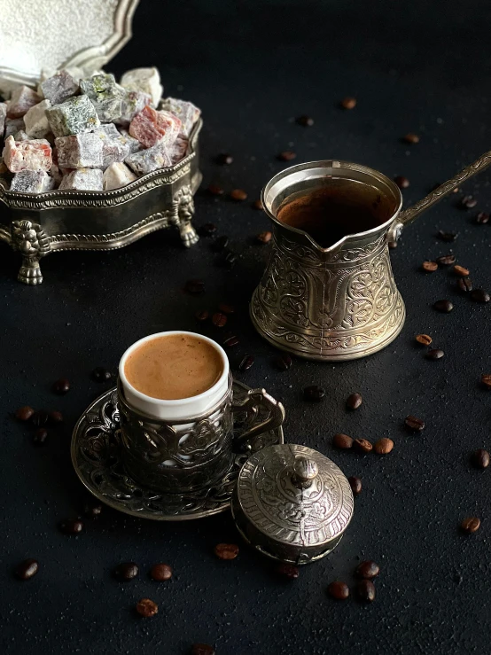 an antique silver coffee pot on top of a black table