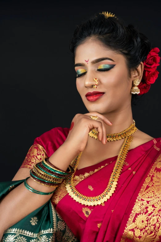 indian woman in sari wearing golden jewelry and green outfit