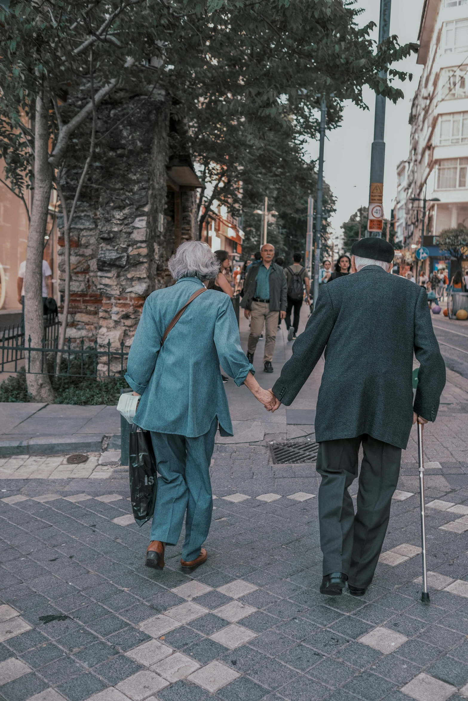 people crossing the street and holding hands