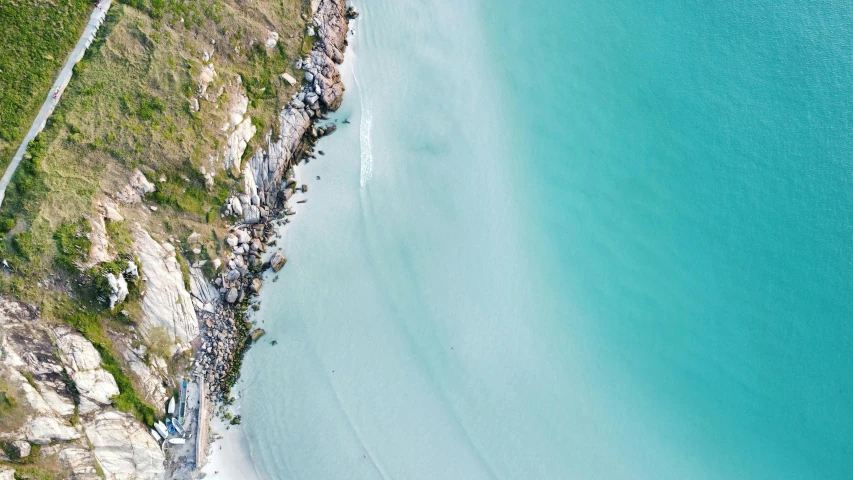 aerial view of a sandy beach with people walking