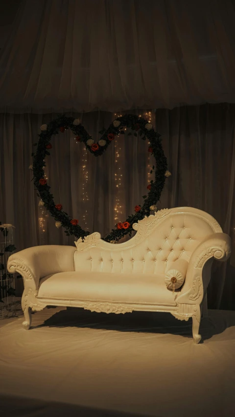 an old fashioned couch with a heart - shaped backdrop